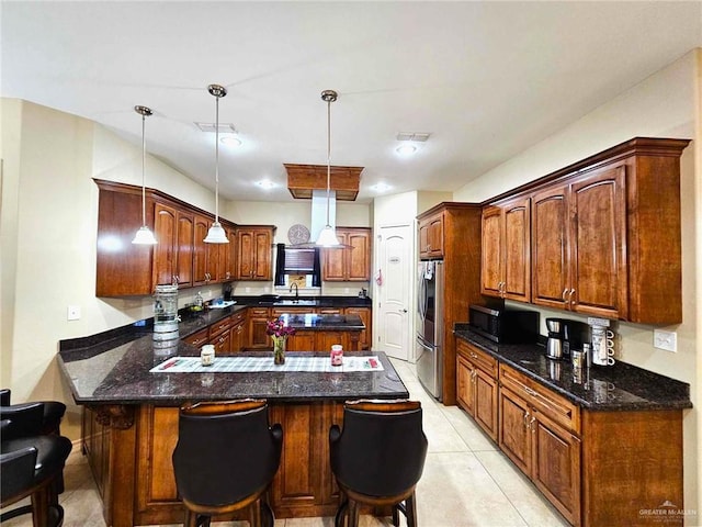 kitchen featuring kitchen peninsula, a breakfast bar, hanging light fixtures, and stainless steel appliances