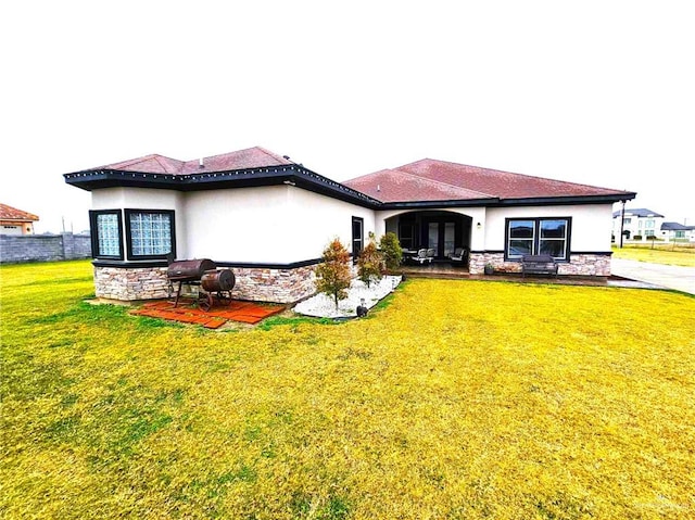 back of house with a patio area and a yard