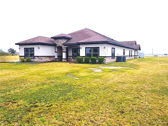 view of front of home with a front yard and central AC unit