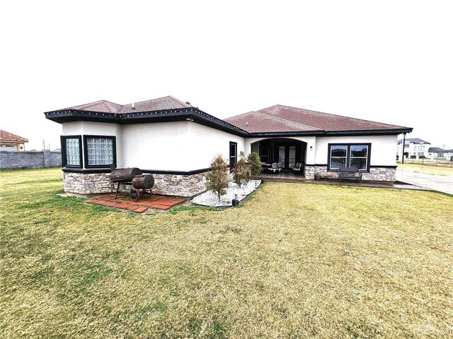 back of property with a yard and a patio