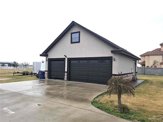 view of side of home featuring a garage and a lawn