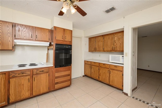 2805 N Blake St, Harlingen, TX 78550 - kitchen with white appliances, under cabinet range hood, brown cabinets, light countertops, and a textured ceiling