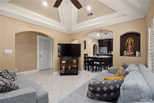 living room featuring ceiling fan, light tile patterned flooring, and a raised ceiling