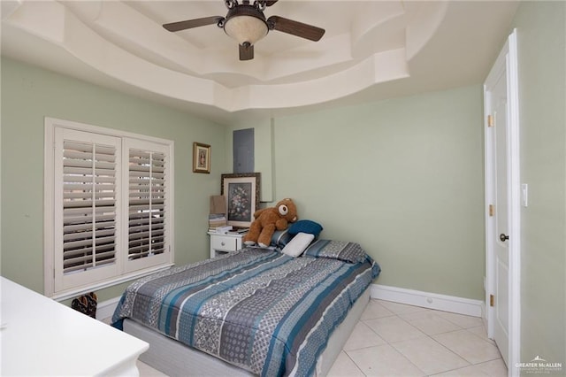 bedroom featuring a tray ceiling, ceiling fan, and light tile patterned flooring