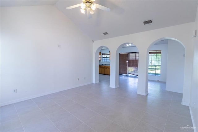 spare room with visible vents, lofted ceiling, baseboards, and ceiling fan