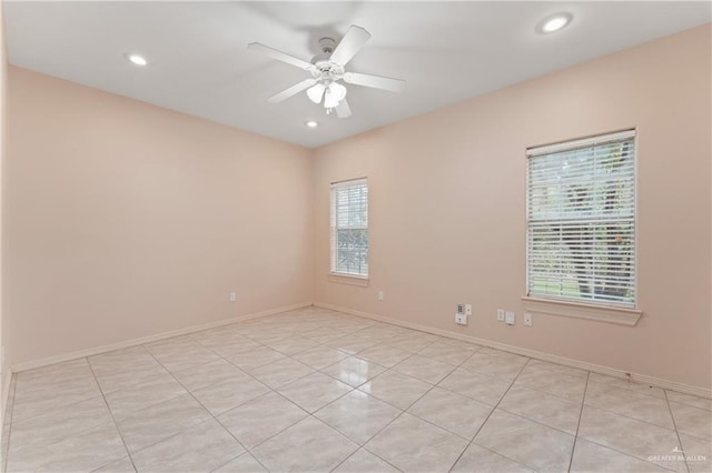 tiled empty room featuring ceiling fan