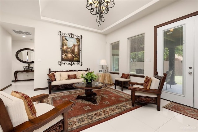 living area with light tile patterned flooring and an inviting chandelier