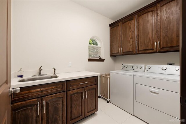 clothes washing area with cabinets, separate washer and dryer, light tile patterned flooring, and sink