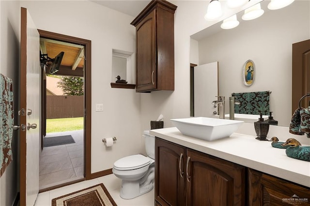 bathroom with toilet, vanity, and tile patterned floors