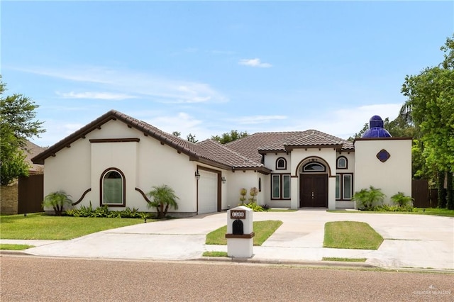 mediterranean / spanish home with a front yard and a garage