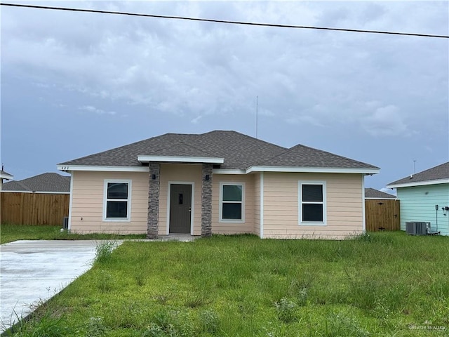 view of front facade with a front yard and central AC unit