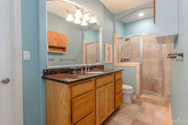 bathroom featuring tile patterned floors, vanity, toilet, and an enclosed shower