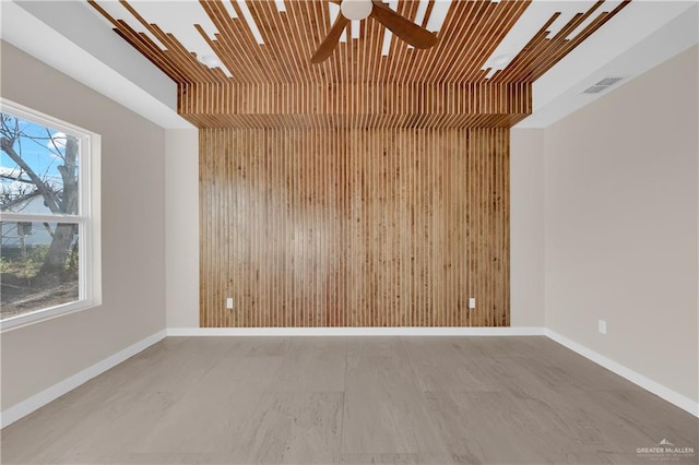 spare room featuring wood ceiling, ceiling fan, wooden walls, and baseboards