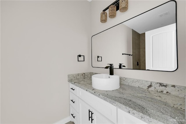 bathroom with baseboards, visible vents, and vanity