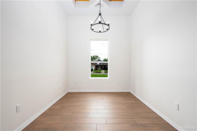 empty room featuring hardwood / wood-style flooring and an inviting chandelier