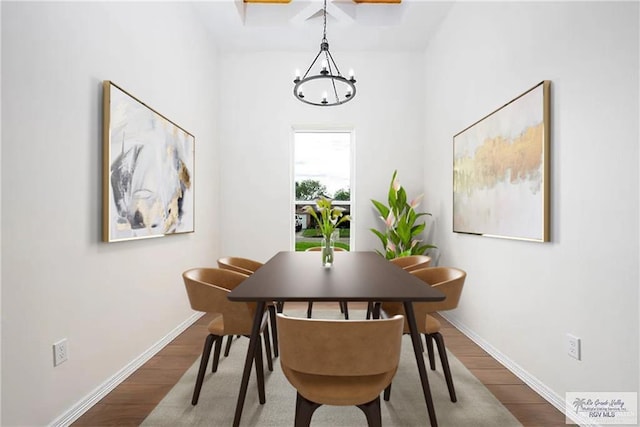 dining space with a notable chandelier, baseboards, and wood finished floors