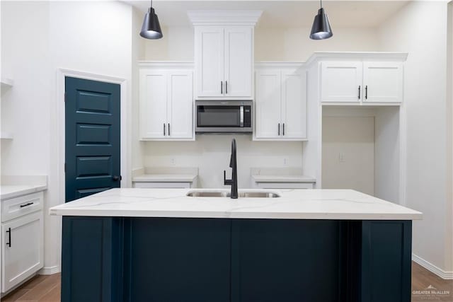 kitchen with pendant lighting, light stone countertops, and white cabinetry