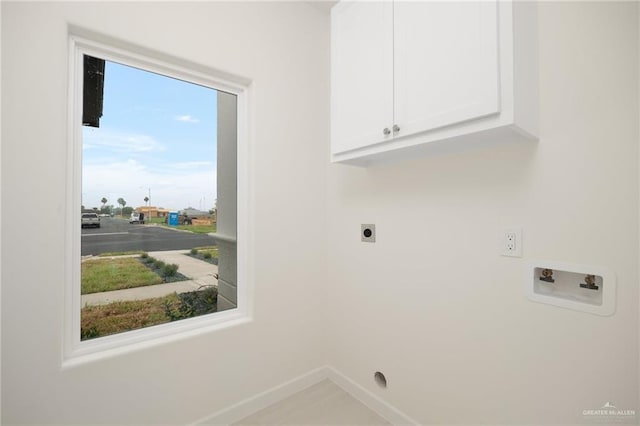 laundry area with baseboards, hookup for a washing machine, cabinet space, and electric dryer hookup