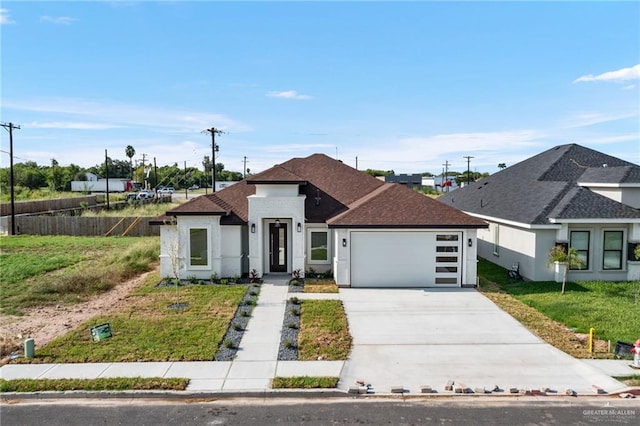 view of front of property with a garage, stucco siding, concrete driveway, and a front yard