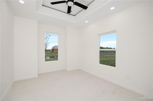 spare room featuring baseboards, a raised ceiling, a ceiling fan, and recessed lighting