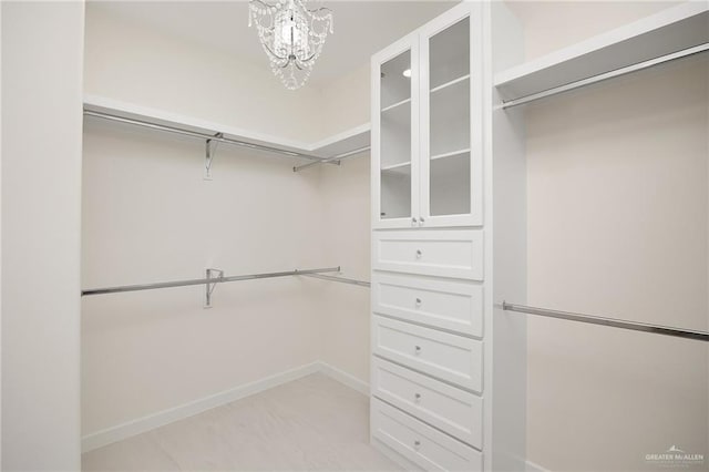 spacious closet featuring a chandelier