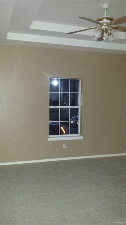 spare room with a raised ceiling and ceiling fan