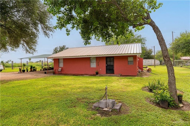 21707 Hidalgo St, Edcouch, TX 78538 - view of front of property with a front lawn, a metal roof, dirt driveway, and a carport