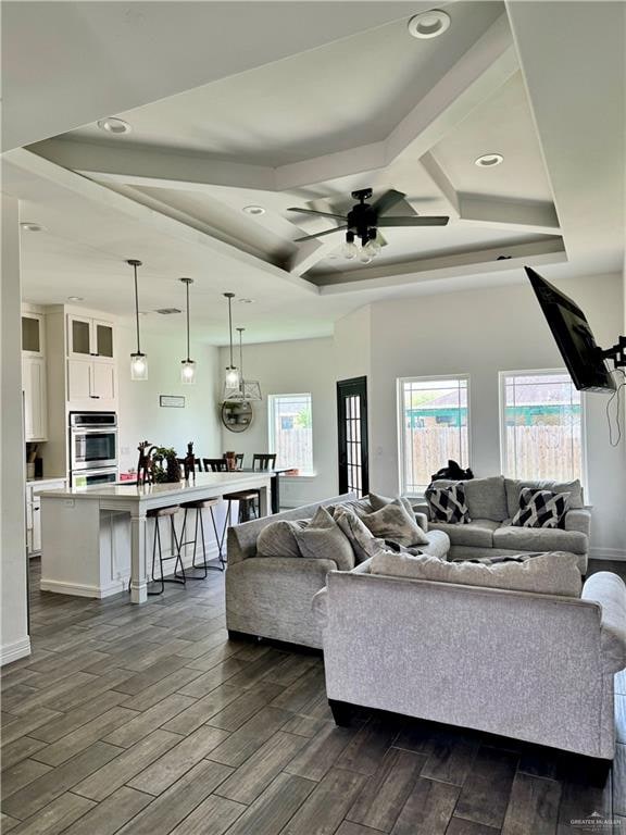 living room featuring beam ceiling, ceiling fan, and dark hardwood / wood-style flooring