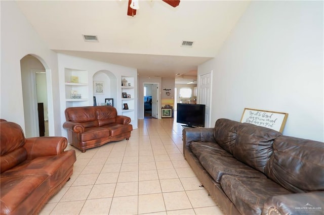 living room featuring light tile patterned floors, ceiling fan, and built in features