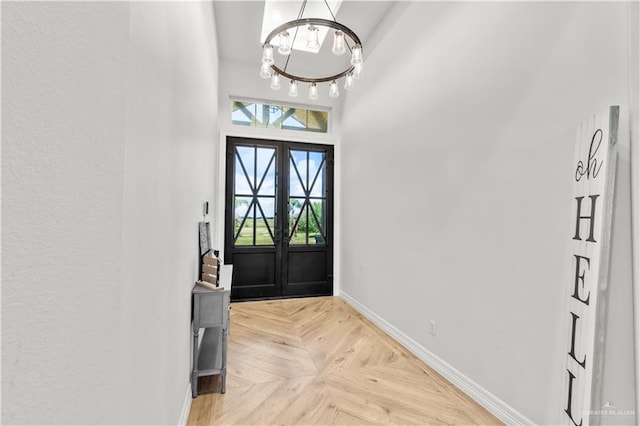 entrance foyer featuring french doors, light parquet flooring, and an inviting chandelier