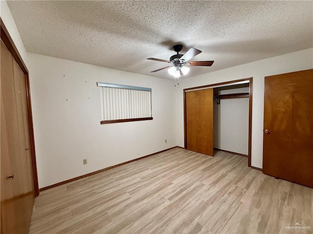 unfurnished bedroom with a closet, baseboards, light wood-style flooring, and a textured ceiling