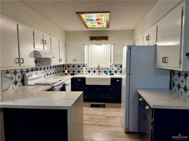 kitchen featuring white electric range, a sink, under cabinet range hood, and white cabinetry