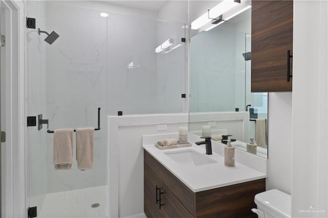 bathroom featuring vanity, toilet, and a shower with door