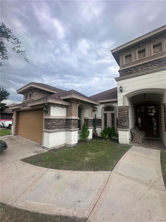 2308 Monte Grande Dr, San Juan, TX 78589 - view of front of home featuring stone siding, driveway, and a garage