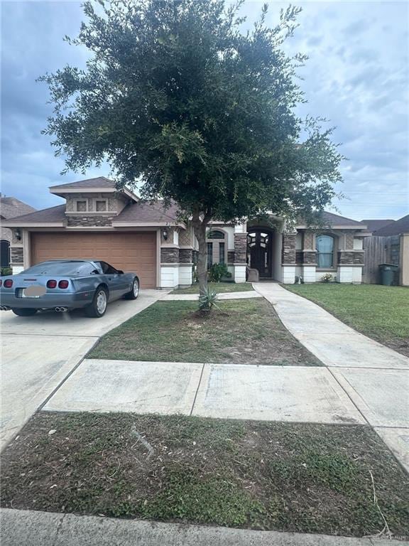 2308 Monte Grande Dr, San Juan, TX 78589 - view of front of house featuring an attached garage, driveway, and a front lawn