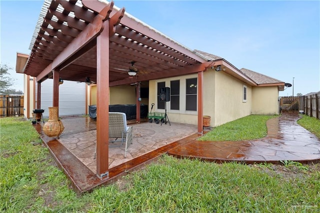 back of house featuring a lawn, a patio area, ceiling fan, and a pergola