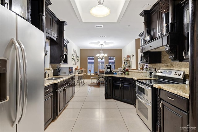 kitchen with pendant lighting, appliances with stainless steel finishes, light tile patterned flooring, and tasteful backsplash