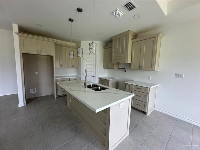 408 Janet Cir N, La Feria, TX 78559 - kitchen with an island with sink, tile patterned flooring, light stone counters, hanging light fixtures, and cream cabinets