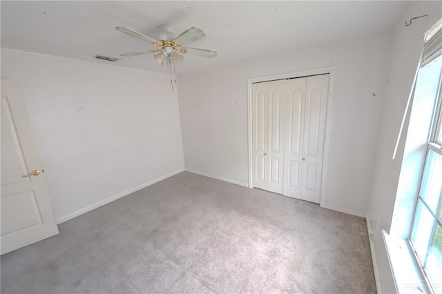 unfurnished bedroom featuring ceiling fan, light carpet, and a closet