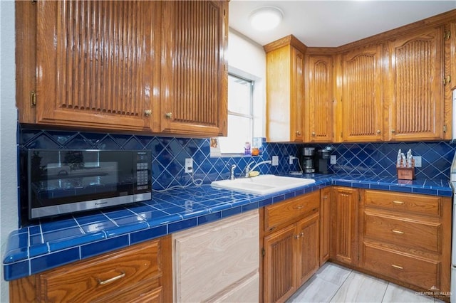 7610 N Ware Rd, Mcallen, TX 78504 - kitchen with backsplash, brown cabinetry, and tile countertops