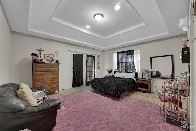 carpeted bedroom with a tray ceiling