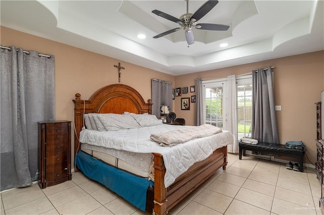 bedroom with a tray ceiling, access to exterior, light tile patterned floors, recessed lighting, and ceiling fan