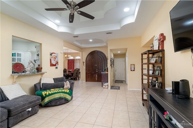 entrance foyer featuring a tray ceiling, ceiling fan, light tile patterned floors, a chandelier, and recessed lighting