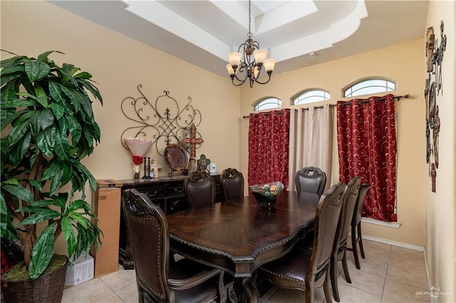 dining area with a chandelier, light tile patterned floors, a raised ceiling, and baseboards