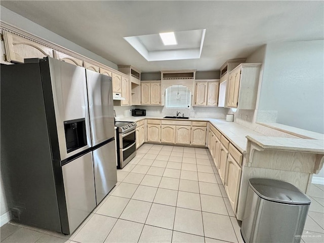 4208 Country St, Edinburg, TX 78541 - kitchen with stainless steel appliances, light brown cabinetry, light tile patterned floors, a sink, and a skylight
