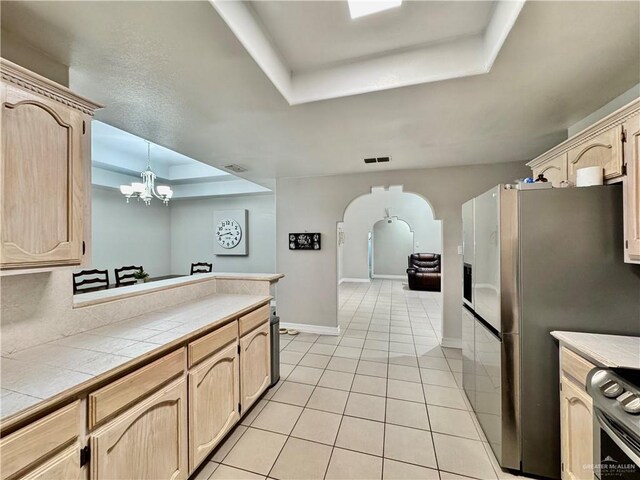 4208 Country St, Edinburg, TX 78541 - kitchen featuring a tray ceiling, light brown cabinets, appliances with stainless steel finishes, and tile countertops