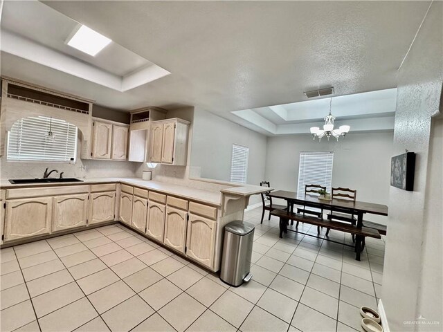 4208 Country St, Edinburg, TX 78541 - kitchen featuring a tray ceiling, light tile patterned floors, light countertops, and a chandelier