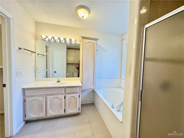 4208 Country St, Edinburg, TX 78541 - bathroom featuring vanity, tile patterned floors, a shower stall, a bath, and a textured ceiling