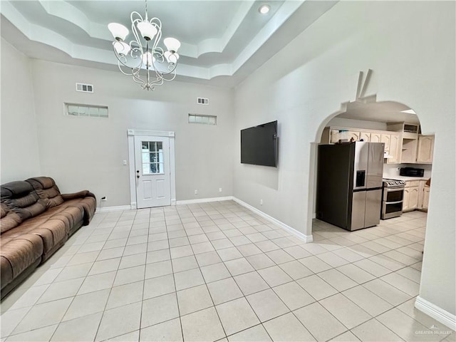4208 Country St, Edinburg, TX 78541 - living area featuring a chandelier, a high ceiling, arched walkways, light tile patterned floors, and baseboards