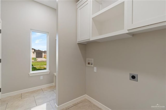 clothes washing area featuring cabinets, hookup for an electric dryer, hookup for a washing machine, and light tile patterned flooring